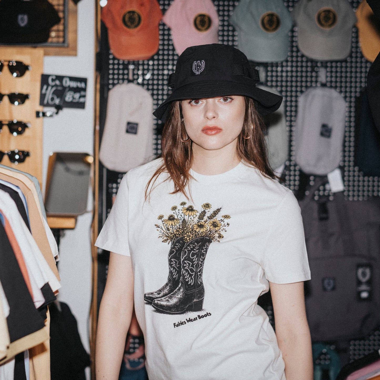 Woman wearing a white t-shirt with a graphic design in a clothing store.